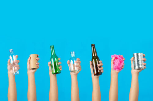 Manos alzando botellas y latas